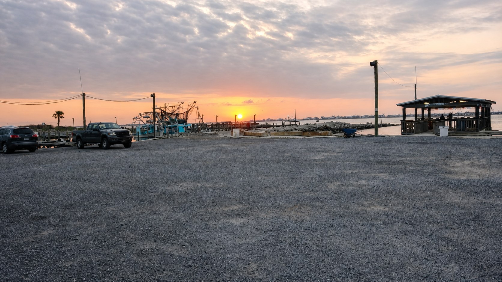 A working Louisiana dock, shrimp boat, and pavilion at sunset